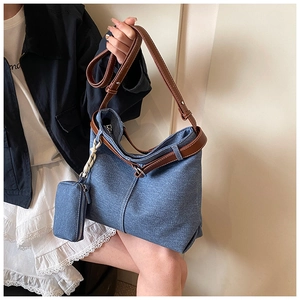 Detail of blue denim tote bag with brown leather straps and detachable coin purse