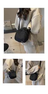 Dettaglio borsa a tracolla nera in nylon con logo metallico tondo e tracolla regolabile