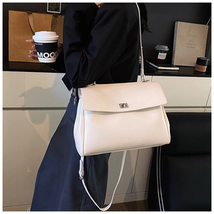 Detail of cream white faux leather shoulder bag with silver clasp and fine grain texture