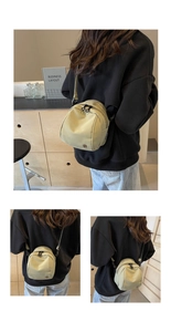 Dettagli della borsa a tracolla in nylon con logo metallico rotondo e cerniere nere