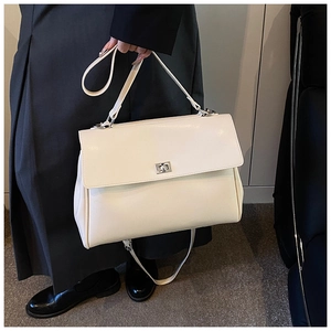 Detail of a large cream PU leather satchel with silver twist lock and top handle