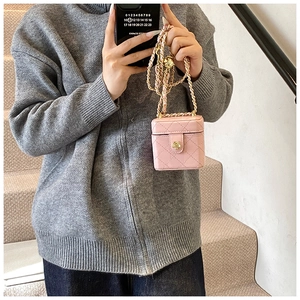 Pink quilted mini crossbody bag with gold camellia clasp and chain strap on model