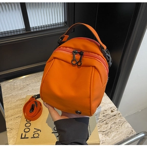 Dettaglio borsa sportiva in nylon arancione con cerniere in metallo nero e tracolla