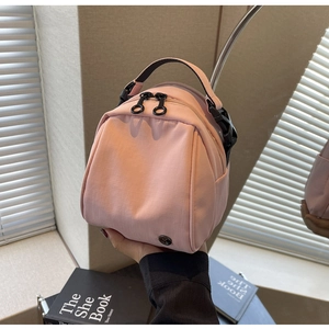 Dettaglio del tessuto in nylon ripstop rosa e logo circolare sulla mini borsa sportiva chic