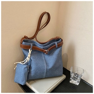 Detail of blue denim tote bag with brown leather straps and matching small coin purse