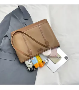 Vista detallada del bolso tote marrón con patrón de lichi y gran capacidad de carga