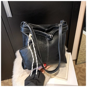 Detail of black faux leather tote with white contrast stitching and mini coin purse