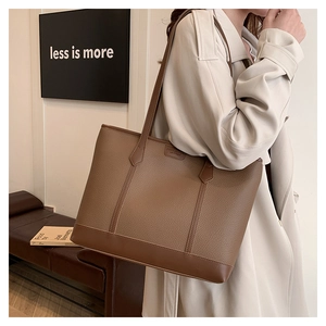 Detalle del bolso tote de cuero marrón oscuro con base reforzada y costuras de alta calidad
