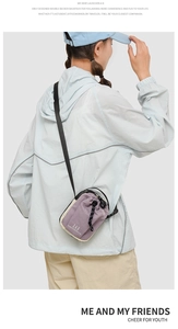 Detail van een paars-beige nylon crossbodytas met trekkoord, gedragen door een model buiten
