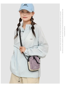 Detail van een paars-beige canvas crossbodytas met trekkoordsluiting en merklogo