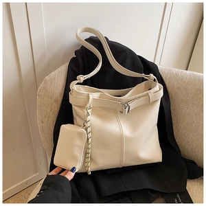 Close-up of a large beige PU leather tote bag with a matching small zipper pouch