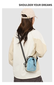 Modelweergave van de blauw-beige utility crossbodytas met handige trekkoordsluiting