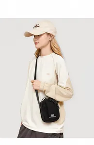 Detail of light beige crossbody bag with drawstrings and matching embroidered cap