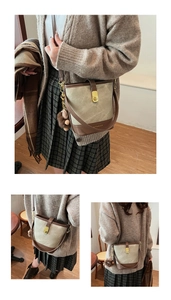 Detail view of contrast color bucket bag featuring a brown teddy bear charm and gold hardware