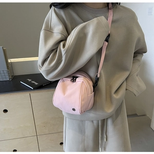 Dettaglio borsa a tracolla in nylon rosa impermeabile con doppia cerniera e tracolla regolabile