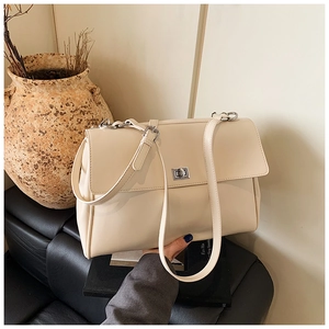 Detail of cream business messenger bag featuring a silver metal twist lock and smooth texture
