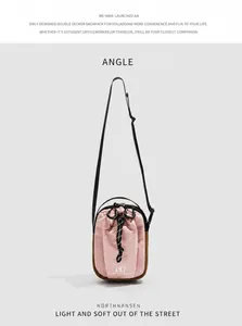 Detail view of pink and brown crossbody phone bag with drawstring pocket and black strap