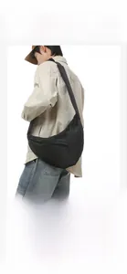 Detail of black nylon crescent bag showing durable water-resistant fabric and zippers