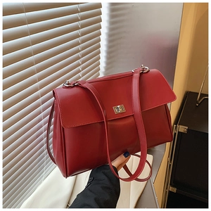Detailed close-up of a red leather briefcase featuring a silver metal twist lock