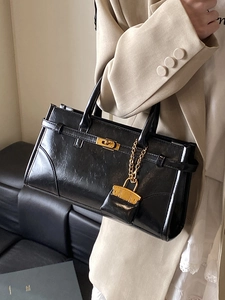 Classic black leather tote handbag with gold metal clasp and detachable small pouch