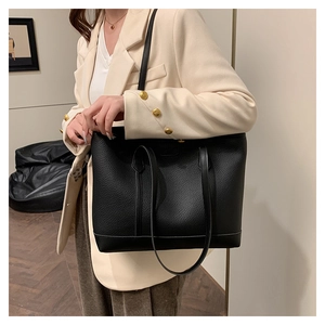 Modelo con bolso tote negro de cuero granulado con asas dobles para uso diario