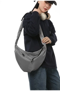 Detail of adjustable black strap and durable gray nylon fabric on messenger bag