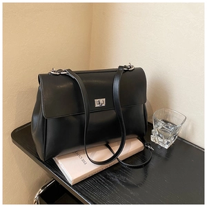 Close-up of black synthetic leather briefcase with elegant silver metal twist lock buckle