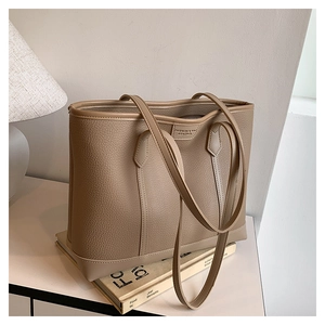 Detalle de bolso tote de cuero granulado con elegante logotipo en relieve