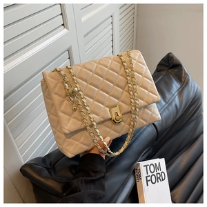 Close-up of beige quilted small square bag with gold chain strap and luxury metal clasp