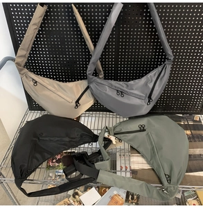 Detailed view of durable nylon crescent bags in four colors on an industrial rack