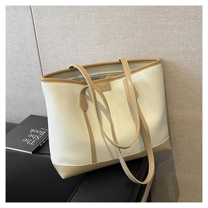 Detalle del bolso tote crema con textura de lichi y borde marrón en contraste