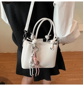 Detail of white oil-wax leather bucket bag with knotted handle and fashion logo