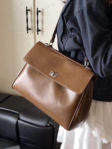 Brown leather crossbody briefcase with silver metal buckle and minimalist commuter design