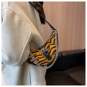 Detailed side view of crescent shoulder bag with tiger print and silver chain link