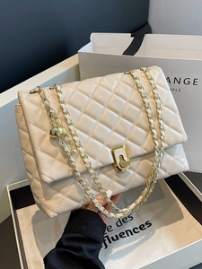 Elegant beige quilted shoulder bag with gold chain strap and turn-lock closure in gift box