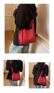 Detail of red litchi texture leather bucket bag with metal protective rivets on base