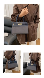 Détail du sac à main en cuir bleu marine et tissu à chevrons avec fermoir doré chic