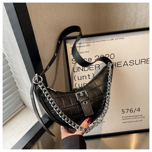 Close-up of black crocodile pattern crescent bag with chunky silver metal chain detail