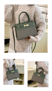 Gros plan du sac à main en cuir et tissu avec un fermoir rotatif en métal doré