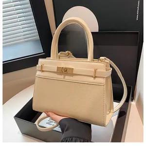 Détail du sac à main en toile beige et cuir avec boucle métallique classique et sangle