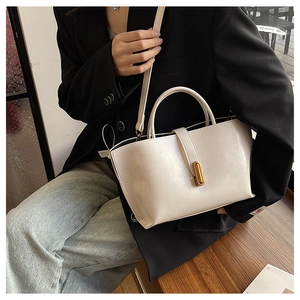 Detailed view of the off-white leather bucket bag with elegant gold metal buckle closure