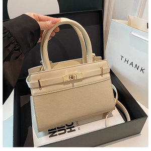 Détail du sac à main crème avec texture en cuir et fermoir doré élégant