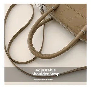 Detail of adjustable shoulder strap and silver buckle on brown embossed leather bucket bag