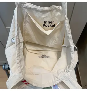 Detailed interior view of a white nylon tote bag showing the main pocket and inner pouch