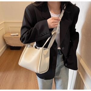 Detail of lychee pattern leather bucket bag with top handle and brand logo