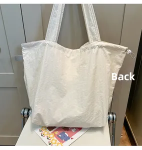 Back view of a cream lightweight nylon tote bag with drawstring texture details