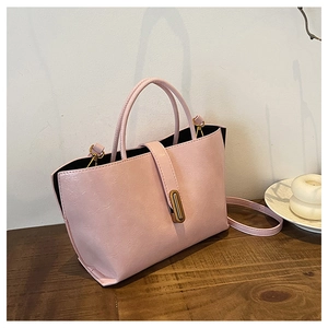 Detail of light pink pebble grain leather texture and elegant golden metal hardware on handbag