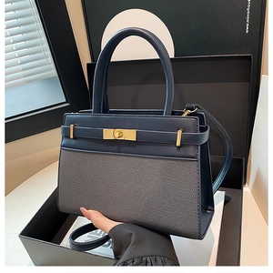 Détail du sac à main bleu marine en cuir et toile avec boucle de verrouillage dorée