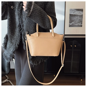 Detail of beige PU bucket bag showing geometric quilted texture and silver hardware