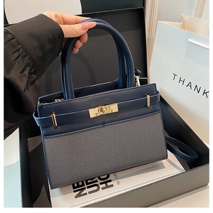 Vue détaillée des textures de cuir et de tissu bleu foncé sur un sac à main